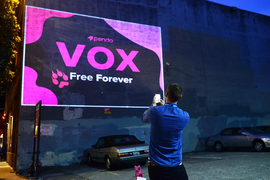Man taking picture of Pendo Digital Projection ad
