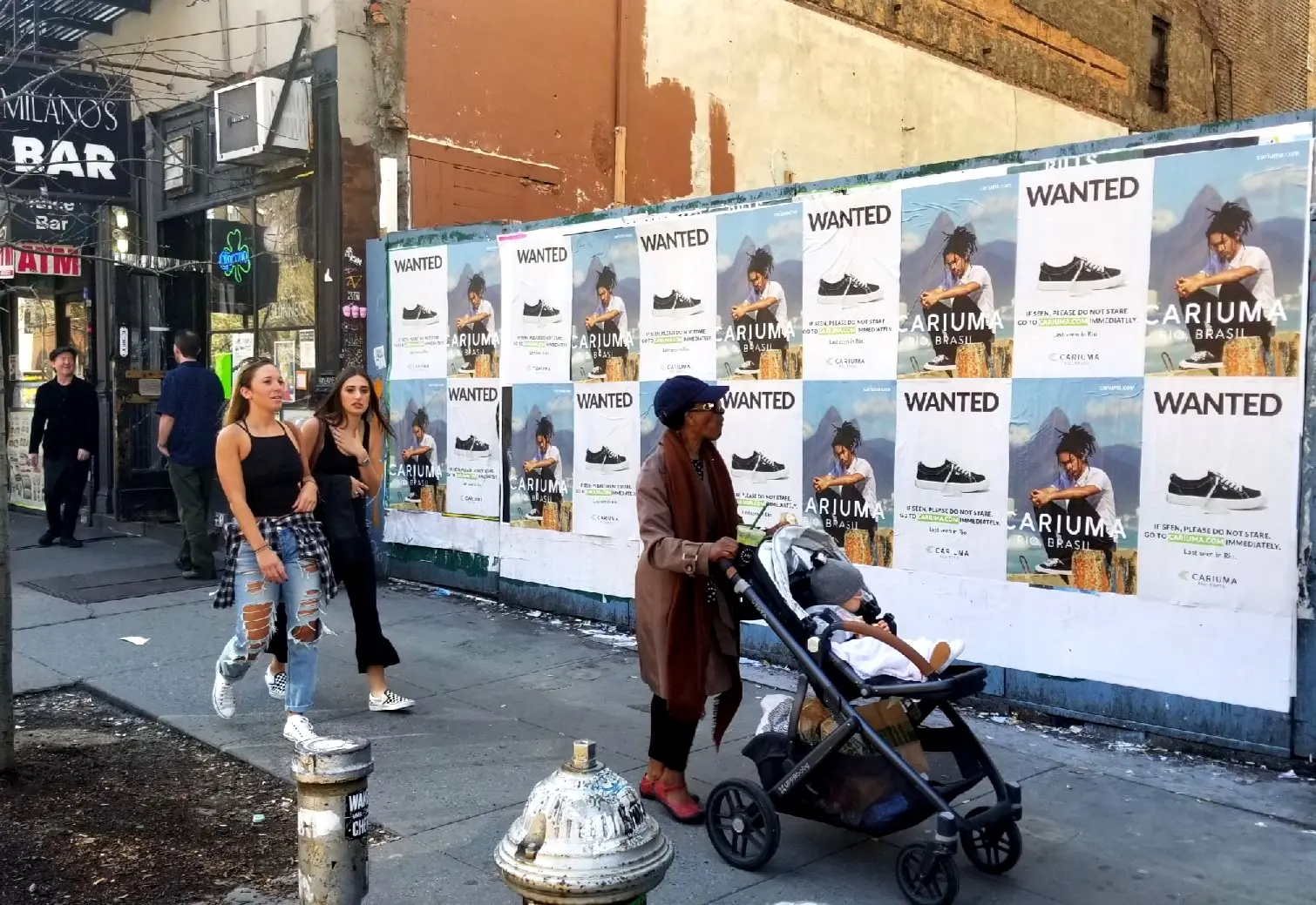 Women walking by Cariuma wild posting ad