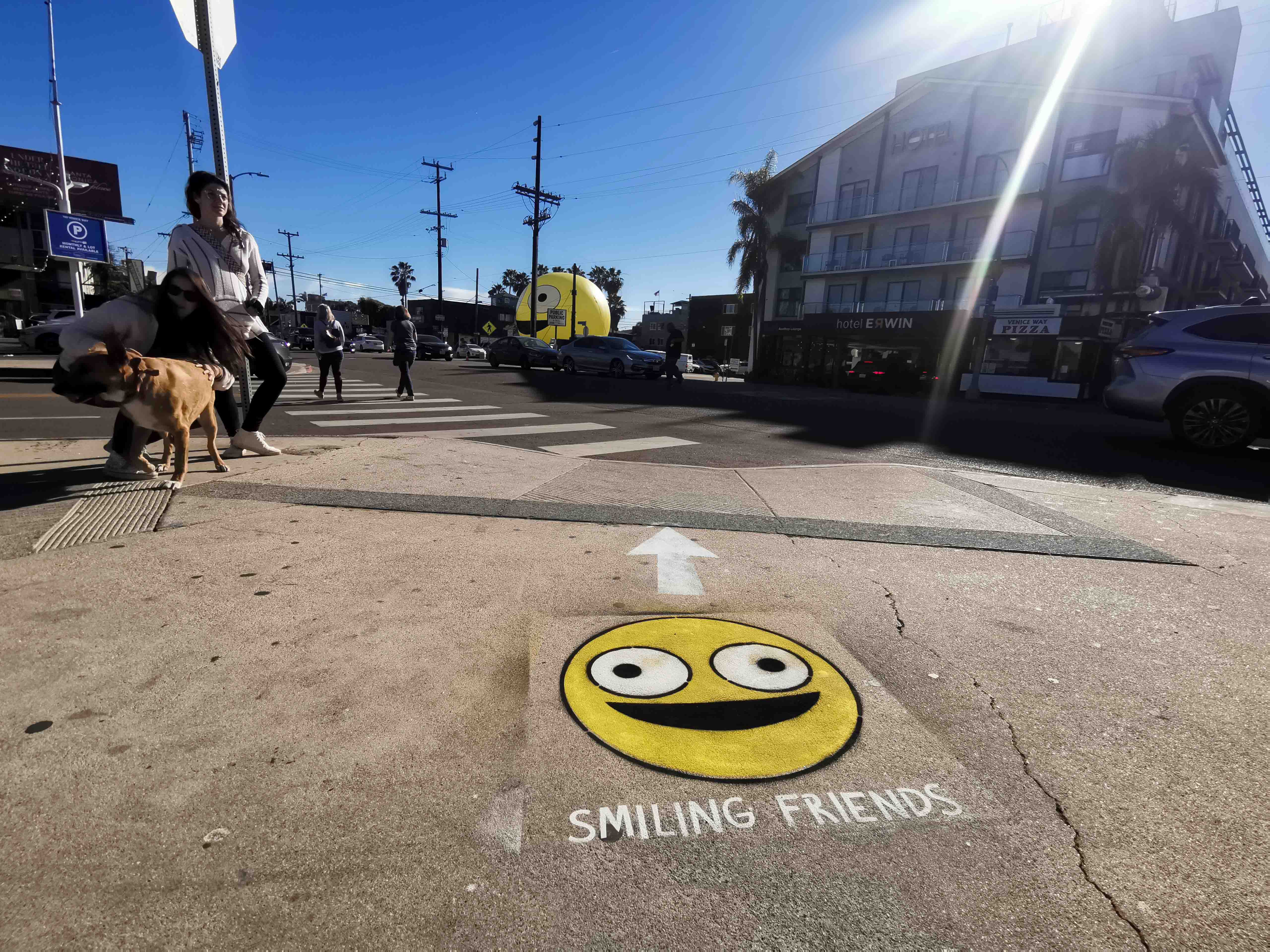 Yellow smiley face chalk stencil on city street