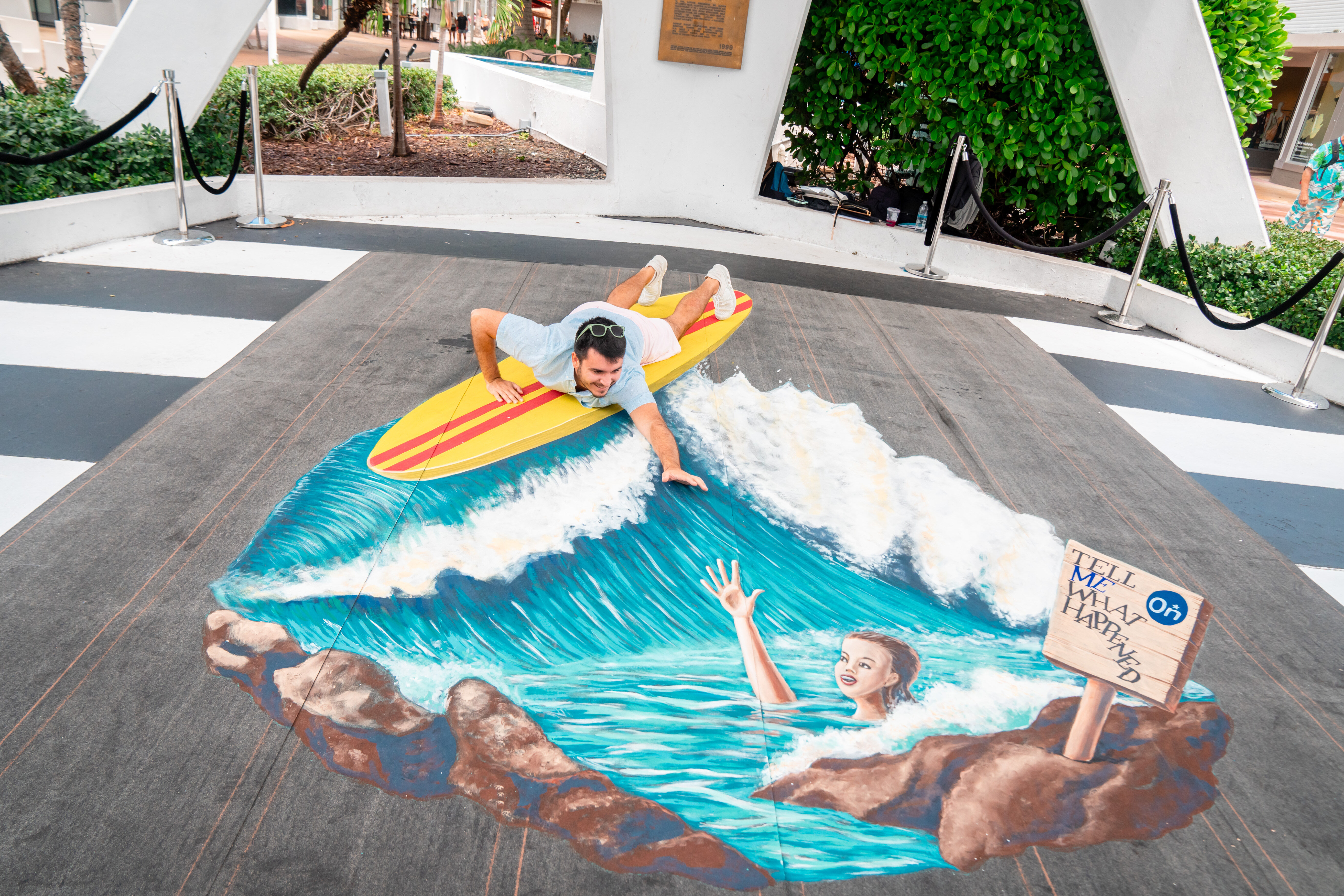 Man on interactive surfboard water mural